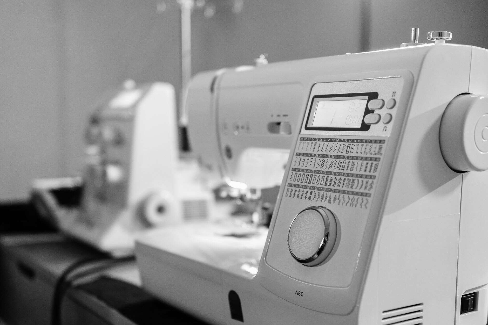Black and white close-up of embroidery machine controls